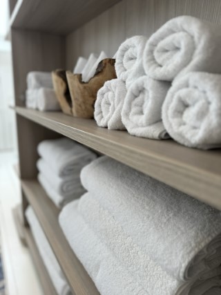 A close-up photo of neatly arranged stacks of clean white towels.